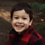 어린이 구강 건강 관리: 어릴 때부터 시작하는 치아 건강 boy in red and black sweater smiling